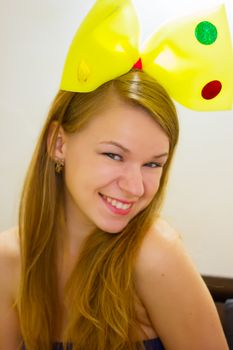 Adult woman of 20 years in children's yellow bow