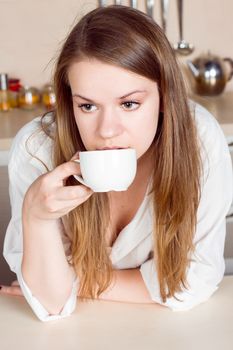 Girl drinks tea from a white cup. close-up