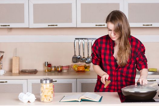 Girl in a red shirt and looking in preparing the book. Horizontal framing