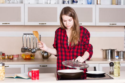 girl in the red shirt is preparing in the kitchen