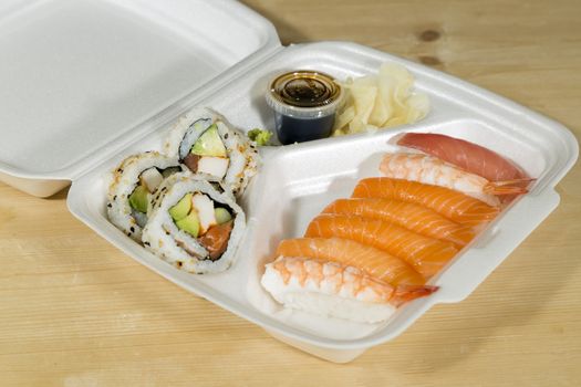Fast Food Sushi in its box on wooden table.