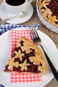 piece of cherry pie on a napkin and  cup of coffee