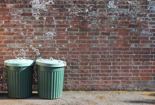 trash can dustbins outside against brick wall