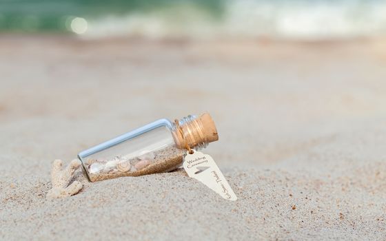 Sand and sea shell in bottle  put on the beach concept for wedding invitation or wedding gift venue on the beach .