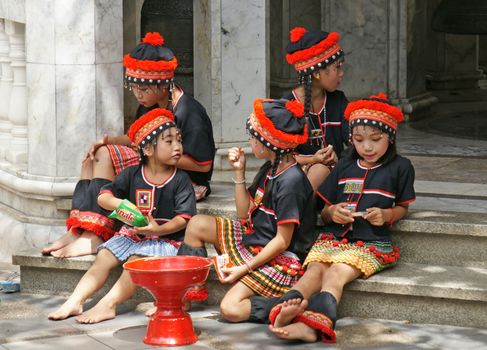 CHIANGMAI, THAILAND - 5 July 2015 : Unidentified hill tribe kids  relax from dance show for donation at Doi Suthep Temple, Chiangmai, north of Thailand.