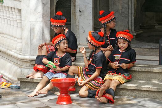 CHIANGMAI, THAILAND - 5 July 2015 : Unidentified hill tribe kids  relax from dance show for donation at Doi Suthep Temple, Chiangmai, north of Thailand.