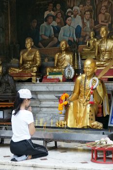 CHIANGMAI, THAILAND - 5 July 2015 : Unidentified female tourism pray to monk sculpture at Doi Suthep Temple, Chiangmai, north of Thailand.