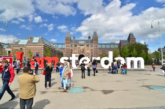 Amsterdam, Netherlands - May 6, 2015: Tourists at the famous sign "I amsterdam" at the Rijksmuseum in Amsterdam on May 6, 2015. Amsterdam is a capital and largest city of Netherlands.