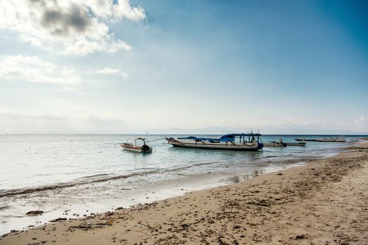 dream sand beach with boat, Bali Indonesia, Nusa Penida island with dramatic blue sky