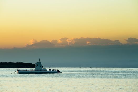Idylic Bali sea, Nusa Penida Island, Toyapakeh, Indonesia -boat with silhouette of Bali at evening with dramatic sky