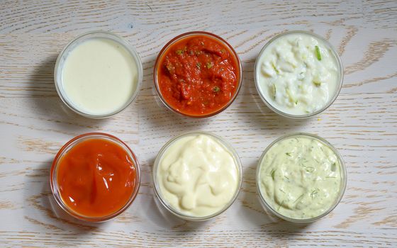 different types of sauces on wooden table