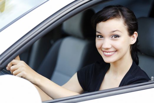 Girl in a car smiling to you.