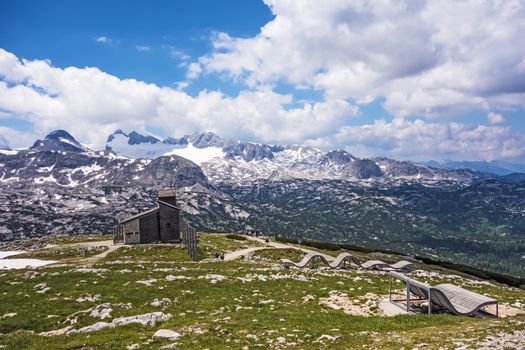 Mountain panorama at Dachstein-Krippenstein, wooden lounger, view of chapel
