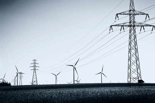 Wind Generators and power lines. Ecology and alternative energy. Dark picture.