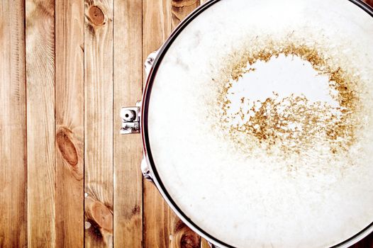 Drums conceptual image. Picture of snare drum lying on wooden background. Retro vintage instagram picture.