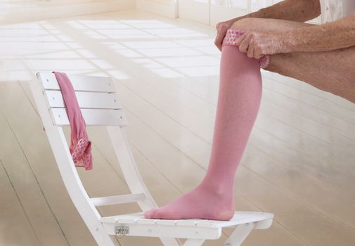 Woman putting thrombosis stockings on