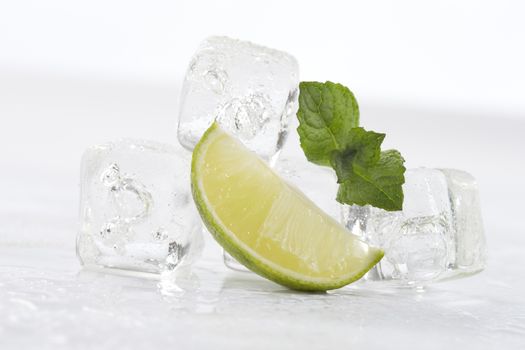 Ice cubes, mint leaves and lime on a white background