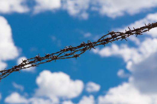 barbed wire background with the sky and clouds