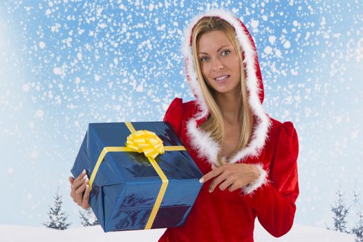 Beautiful young woman in Santa Claus clothes  with gifts on blue sky background