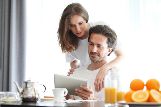 couple at breakfast looking at tablet
