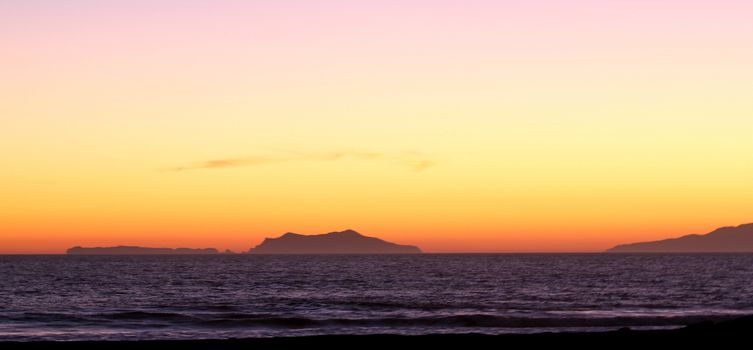 Sunset over the Anacapa island with ocean in the foreground.