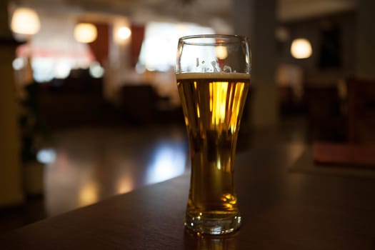 A glass of beer on the corner table in the restaurant.