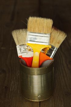 Three clean paint brushes in tin can