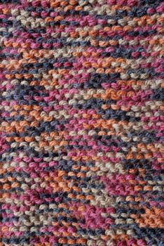 Length of knitting in garter stitch with multi-colored wool as an abstract background texture