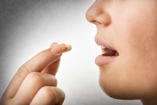 Closeup of woman taking pill