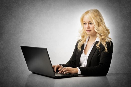 Blond business woman working on laptop