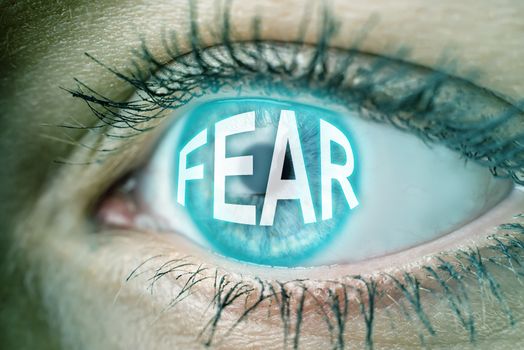 Closeup of the eye of a woman with text FEAR