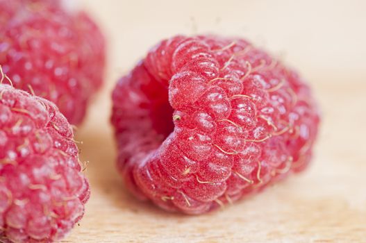 Ripe organic raspberry close up on log