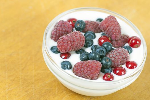 Delicious dessert made of yoghurt and ripe berries (raspberry, red currant and blueberry)