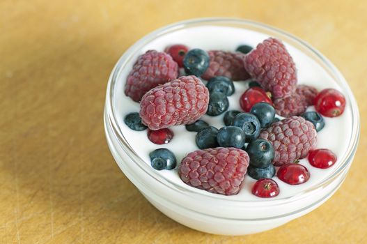 Delicious dessert made of yoghurt and ripe berries (raspberry, red currant and blueberry)