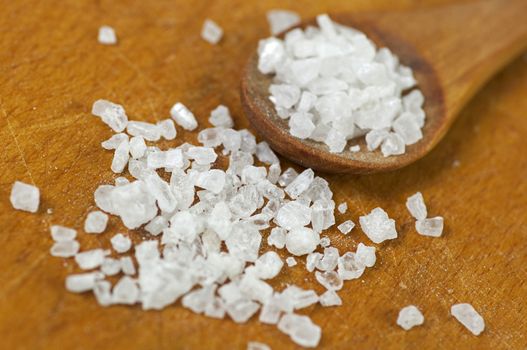 Coarse sea salt close up on light cutting board