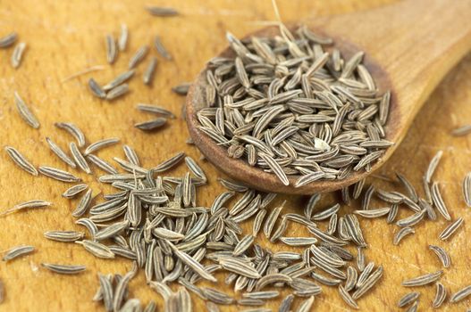 Caraway (Carum carvi) seeds close up on cutting board