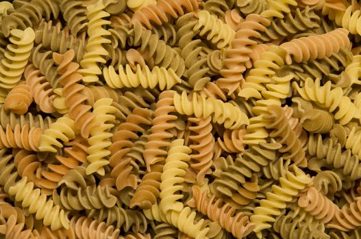 Uncooked multi-colored fusilli, corkscrew-shaped pasta