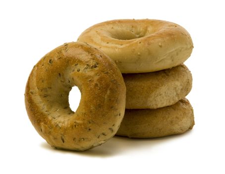 Stack of three bagels with one leaning on the side against white background.