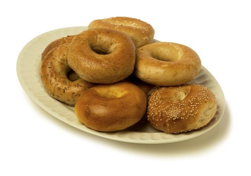A variety of bagels on a platter. isolated against white background