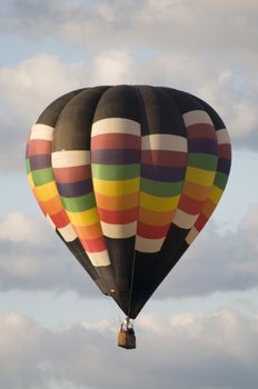 Hot-air balloon floating with clouds in background