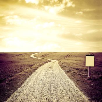 Country road to the horizon with sepia sky. Instagram vintage picture.