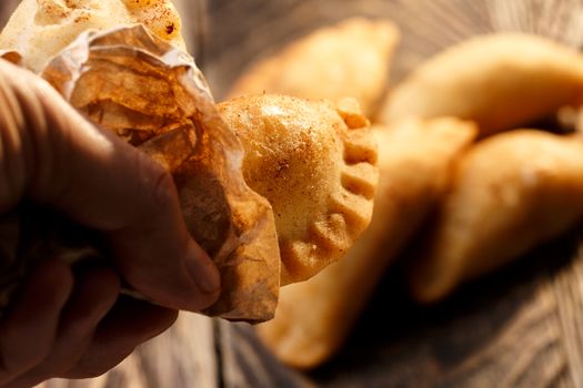 Fried colombian empanadas on wooden table. Savory stuffed patties also known as pastel,pate or pirozhki