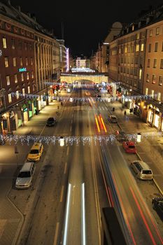 Night traffic on Kungsgatan in central Stockholm. Cars, pedestrians, taxis in traffic close to the crossing with Sveavagen