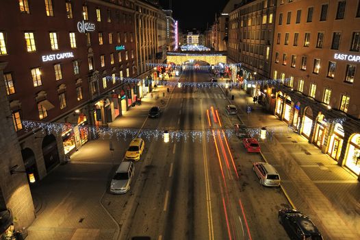 Night traffic on Kungsgatan in central Stockholm. Cars, pedestrians, taxis in traffic close to the crossing with Sveavagen