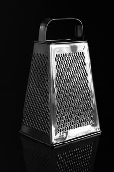 Metal grater with handle isolated on black background