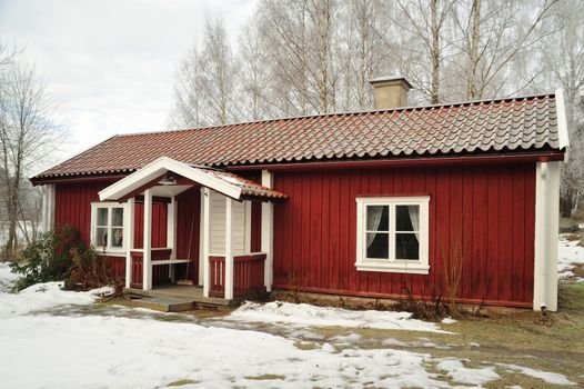 Typical red wooden house in Sweden on a clear and cold winter day