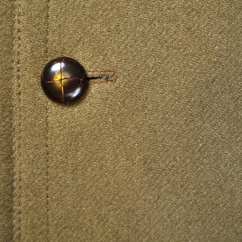 Close-up of a classic green wool coat with button.