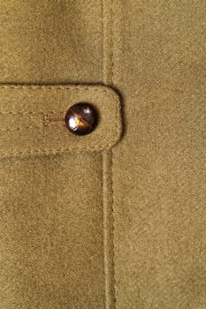Close-up of a classic green wool coat with button.
