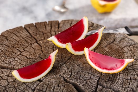 Lemon tequila strawberry jelly (jello) shots on a old wooden wheel. Unusual adult party drinks