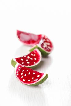 Watermelon like tequila  jelly (jello) shots made out of carved lime on bleached wooden table. Unusual adult party drinks